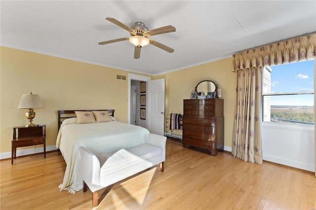 bedroom with light hardwood / wood-style flooring, ceiling fan, and crown molding