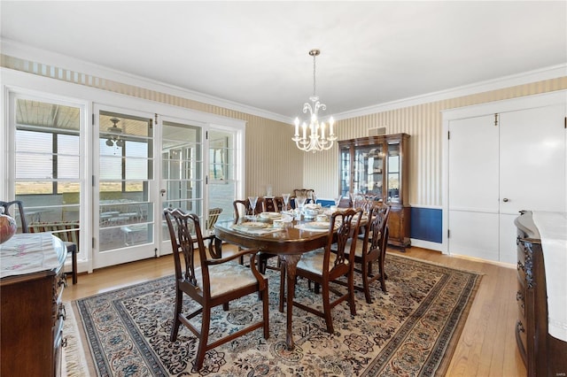 dining space with hardwood / wood-style flooring, a notable chandelier, and ornamental molding