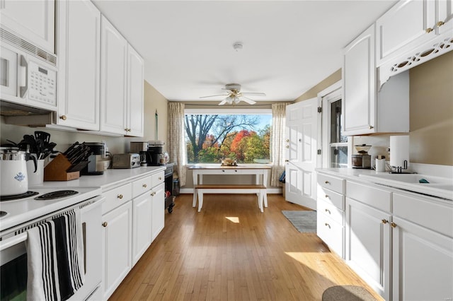 kitchen with white cabinets, white appliances, light hardwood / wood-style flooring, and ceiling fan