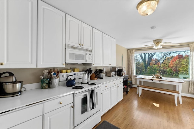 kitchen with white cabinets, white appliances, light hardwood / wood-style flooring, and ceiling fan