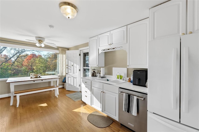 kitchen featuring dishwasher, white fridge, white cabinets, and sink