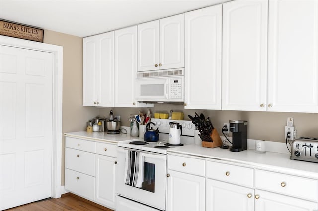 kitchen featuring white cabinets, wood-type flooring, and white appliances