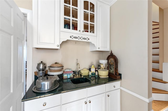 kitchen with white cabinets, hardwood / wood-style flooring, and sink