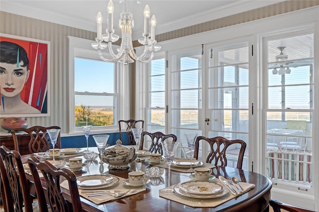 dining area featuring crown molding and ceiling fan with notable chandelier