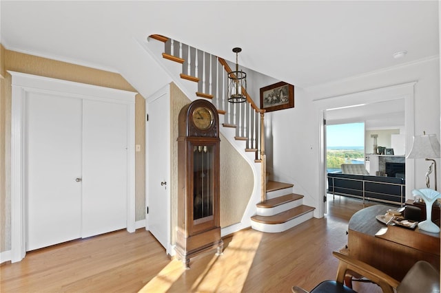 stairs featuring crown molding and hardwood / wood-style flooring