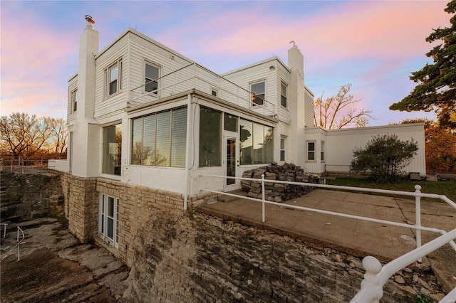 property exterior at dusk with a sunroom