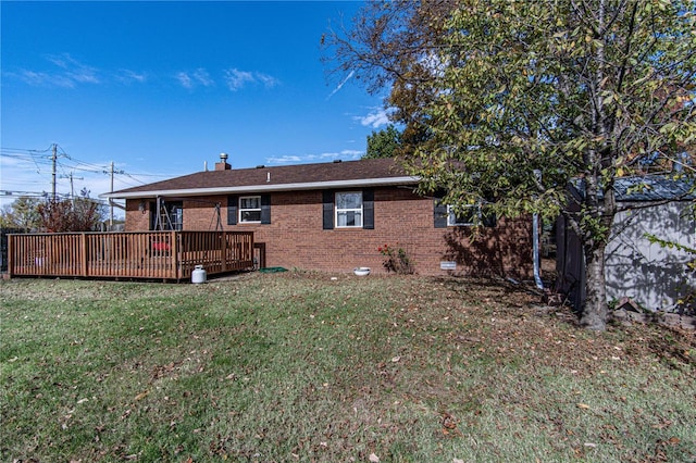 rear view of property featuring a lawn and a deck