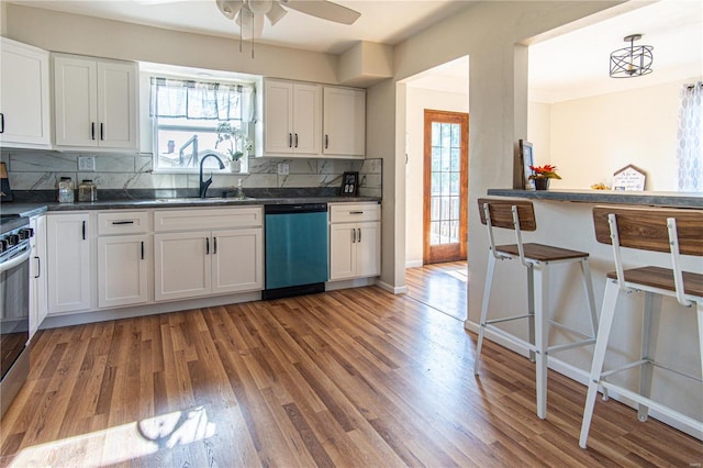 kitchen featuring white cabinets, tasteful backsplash, stainless steel dishwasher, and sink