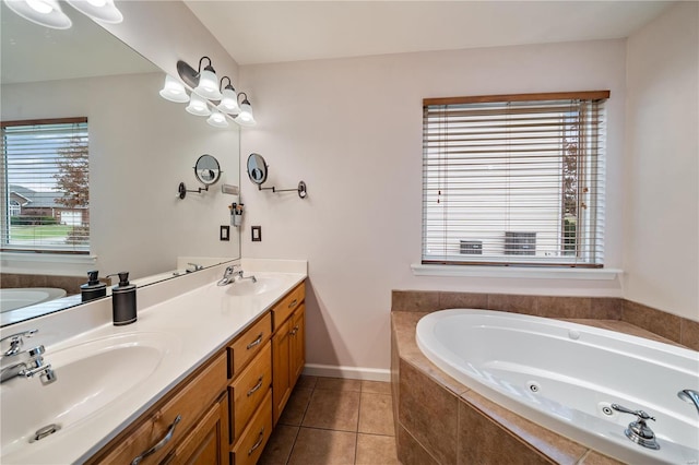 bathroom with tile patterned flooring, vanity, a wealth of natural light, and tiled tub