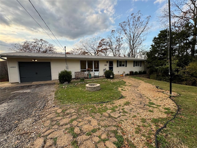 ranch-style house with a fire pit, a garage, and a front yard