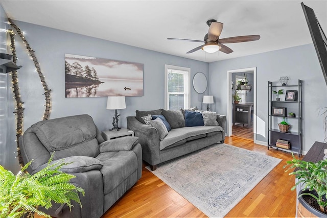 living room with wood-type flooring and ceiling fan