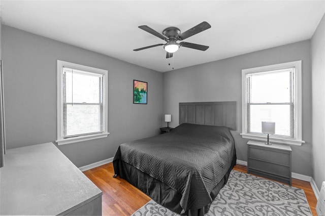 bedroom with multiple windows, ceiling fan, and light hardwood / wood-style flooring