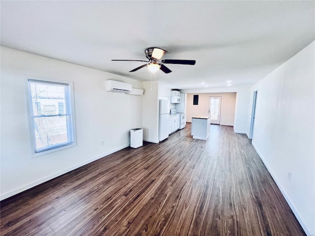 unfurnished living room featuring a wall mounted air conditioner, dark hardwood / wood-style floors, and ceiling fan