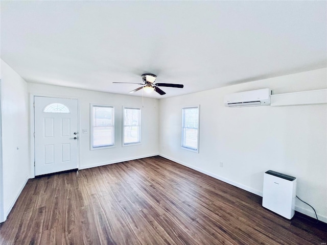 foyer featuring ceiling fan, dark wood-type flooring, and a wall unit AC