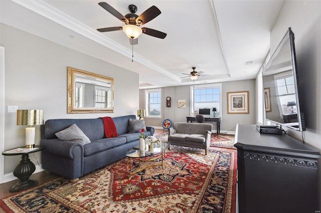 living room with a raised ceiling and ceiling fan