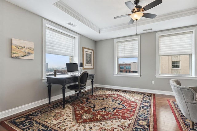 office featuring a raised ceiling, ceiling fan, crown molding, and wood-type flooring