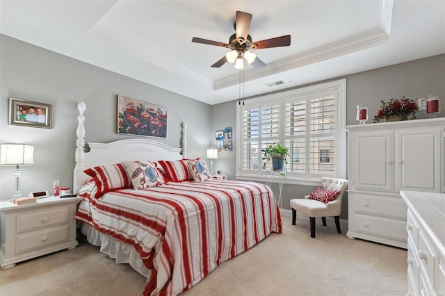 carpeted bedroom featuring a tray ceiling, ceiling fan, and ornamental molding