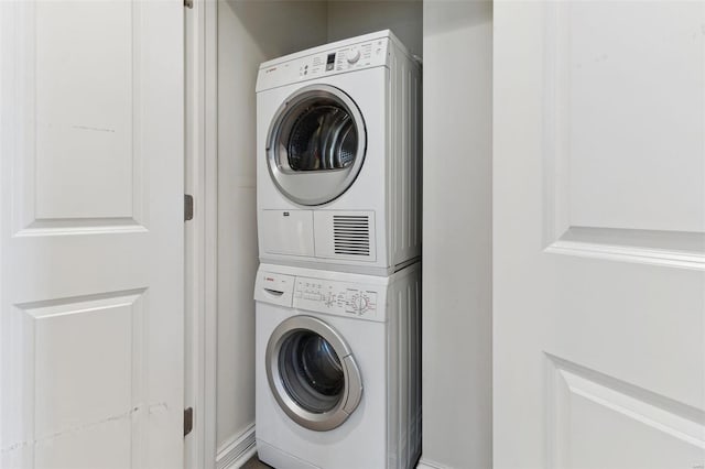 laundry room with stacked washing maching and dryer