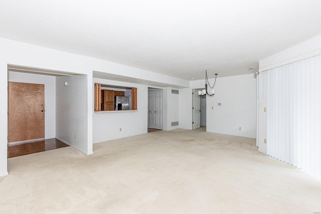 carpeted spare room with a chandelier