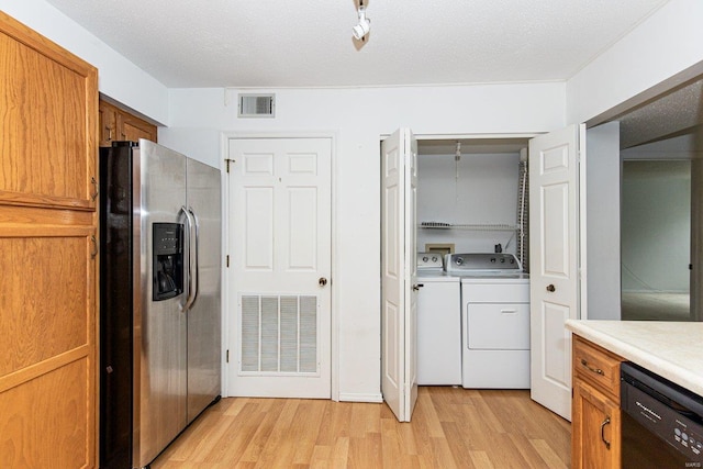 kitchen featuring dishwasher, stainless steel fridge, light wood-type flooring, a textured ceiling, and washing machine and clothes dryer