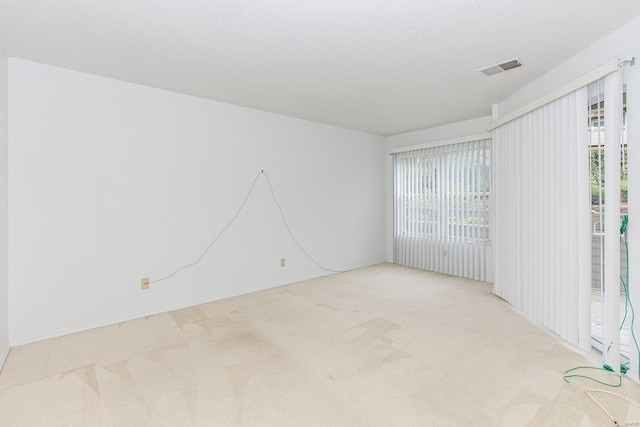 carpeted spare room featuring a textured ceiling