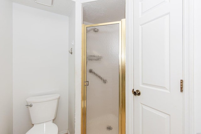 bathroom with a textured ceiling, toilet, and a shower with shower door