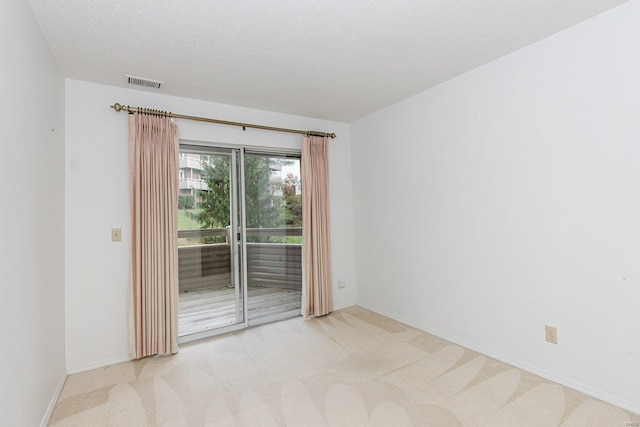 carpeted empty room featuring a textured ceiling