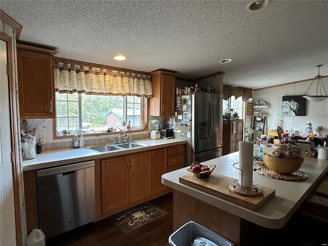 kitchen featuring appliances with stainless steel finishes, a textured ceiling, dark hardwood / wood-style flooring, decorative backsplash, and sink