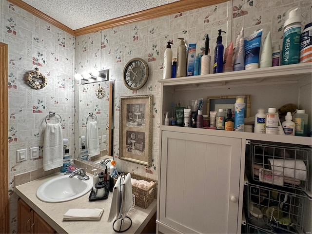 bathroom featuring vanity, a textured ceiling, and ornamental molding