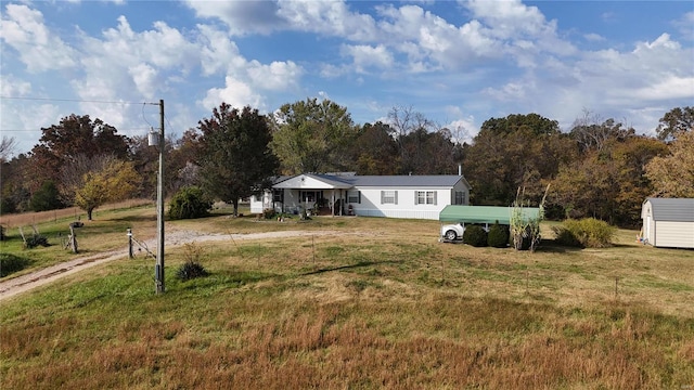 view of front of house with a storage shed and a front yard