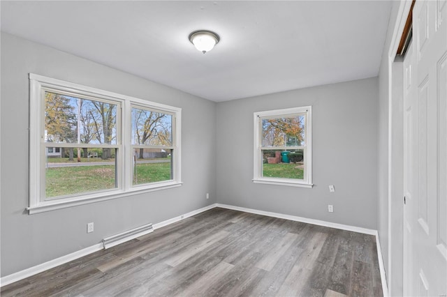 spare room with dark hardwood / wood-style flooring and a wealth of natural light