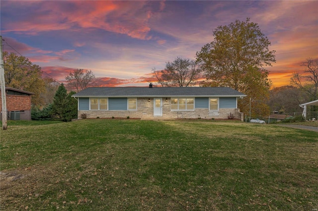 single story home with cooling unit and a lawn