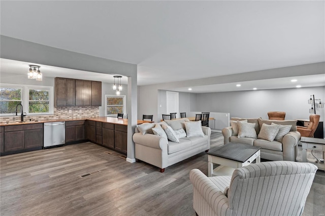 living room featuring hardwood / wood-style floors, a notable chandelier, and sink