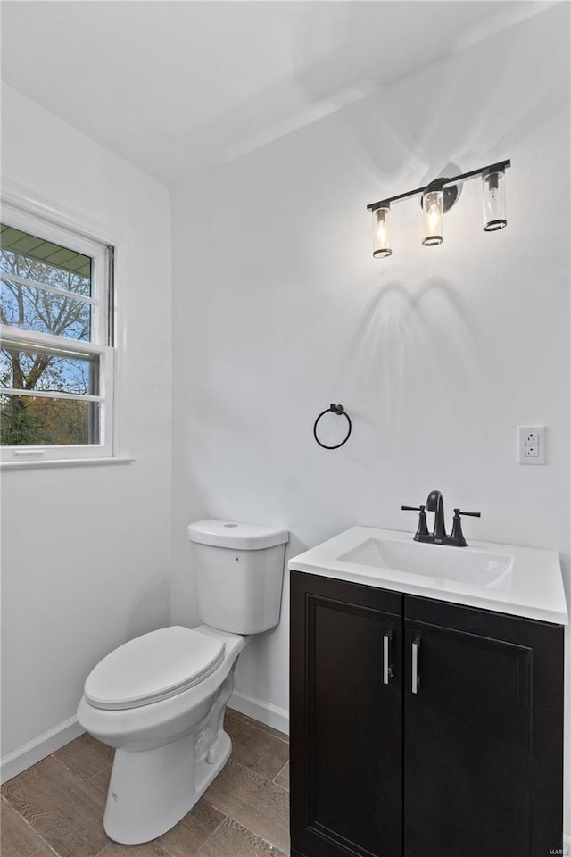 bathroom with hardwood / wood-style flooring, vanity, and toilet