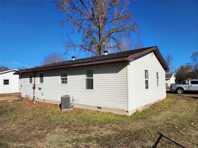 view of property exterior with central air condition unit and a yard