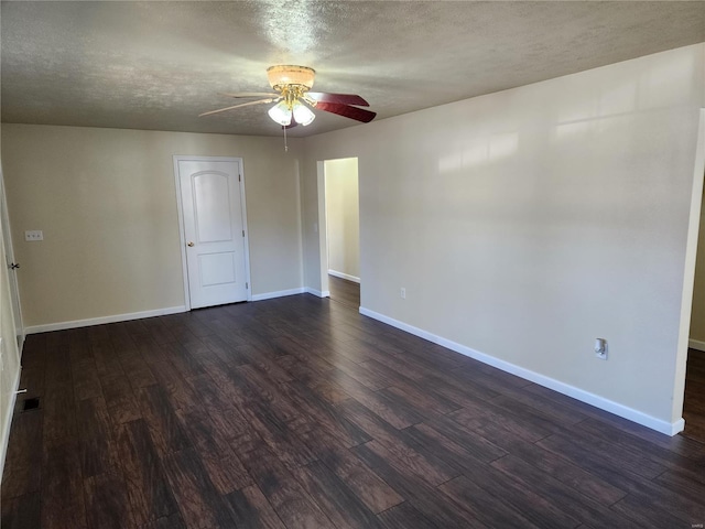 empty room featuring dark wood-type flooring, ceiling fan, and a textured ceiling