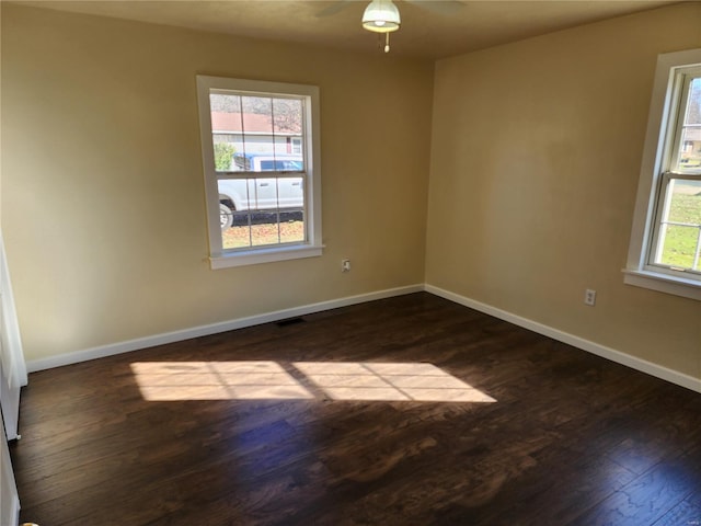 empty room with ceiling fan and dark hardwood / wood-style flooring