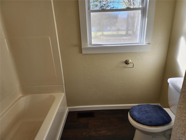 bathroom with toilet and wood-type flooring