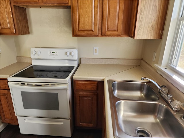 kitchen with white range with electric stovetop and sink