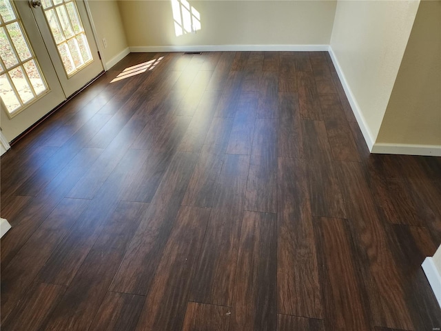 empty room featuring dark hardwood / wood-style flooring and french doors