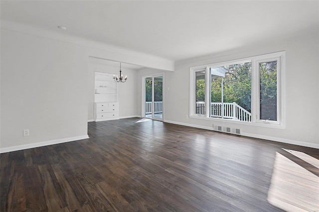 unfurnished living room featuring dark hardwood / wood-style flooring and a chandelier