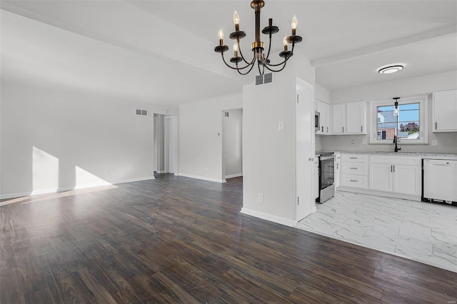 kitchen with white dishwasher, white cabinets, hardwood / wood-style floors, and a chandelier