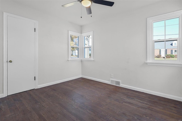 empty room with dark hardwood / wood-style floors, ceiling fan, and a wealth of natural light