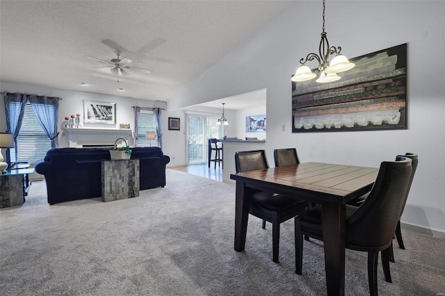 dining space with carpet flooring, lofted ceiling, a textured ceiling, and ceiling fan with notable chandelier