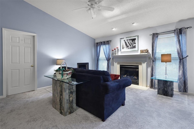 living room featuring a wealth of natural light, ceiling fan, light carpet, and a textured ceiling