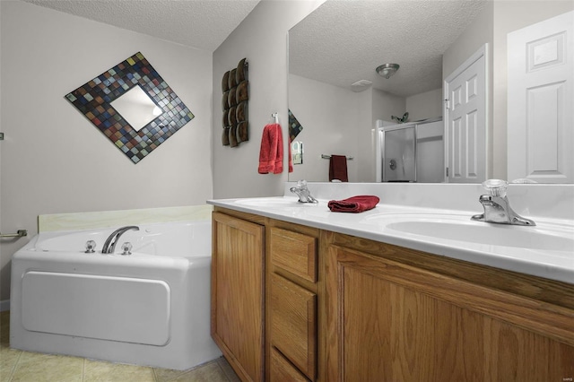 bathroom with tile patterned floors, plus walk in shower, vanity, and a textured ceiling