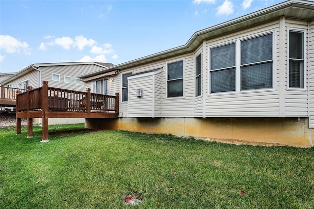 rear view of property featuring a yard and a wooden deck