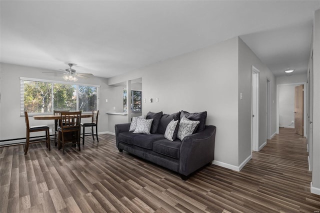 living room featuring ceiling fan, baseboard heating, and dark hardwood / wood-style floors