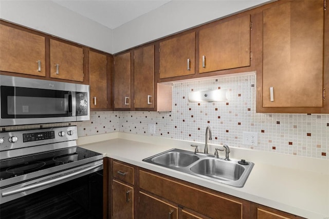 kitchen featuring stainless steel appliances, tasteful backsplash, and sink