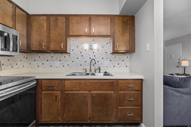 kitchen with decorative backsplash, sink, and stainless steel appliances